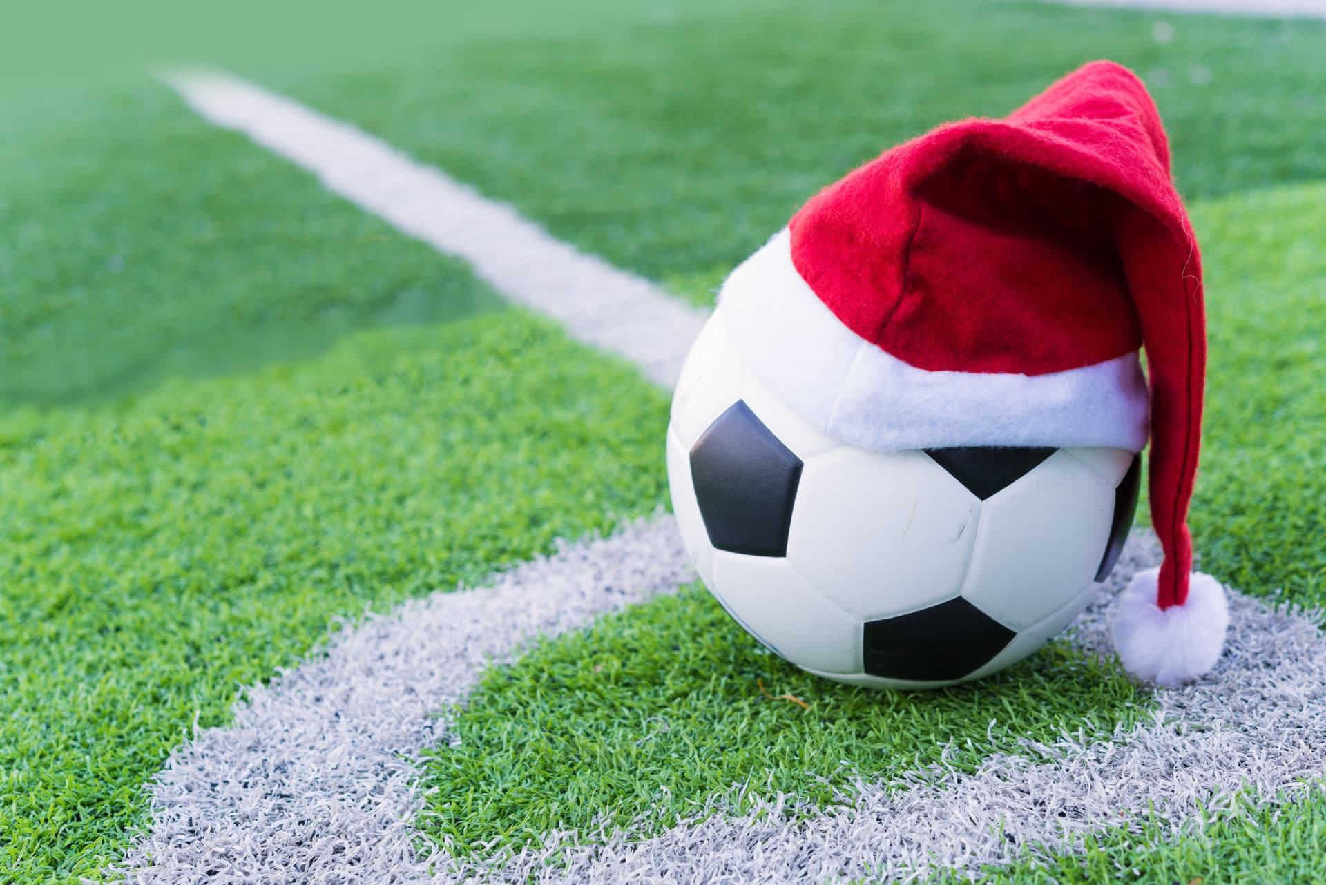 Santa Claus red hat on soccer ball at green grass Juneau Holiday Cup